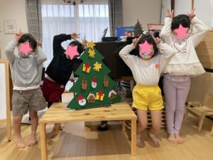 クリスマスツリーと一緒に写真に写るこどもたち