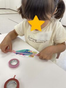 マスキングテープで魚を作る女の子