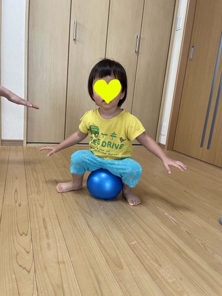 ボールの上に座ってゆらゆらする男の子